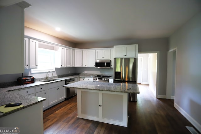 kitchen featuring white cabinetry, dark wood-type flooring, appliances with stainless steel finishes, stone countertops, and sink