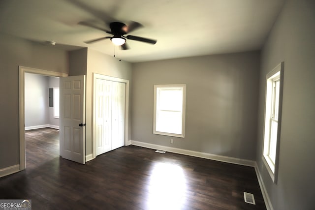 unfurnished bedroom featuring ceiling fan, dark hardwood / wood-style flooring, and a closet