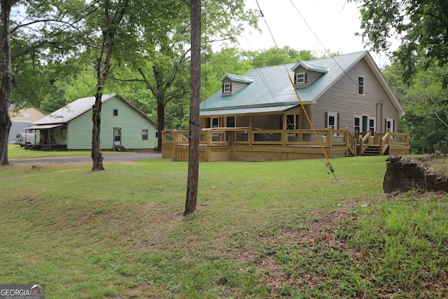 rear view of house featuring a lawn and a wooden deck