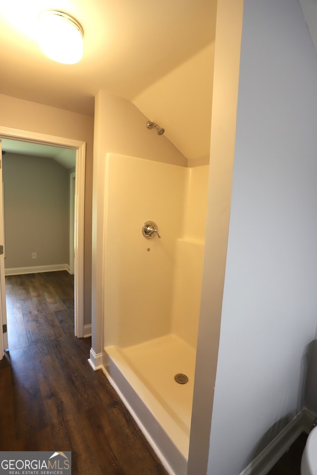 bathroom with a shower, lofted ceiling, and hardwood / wood-style floors