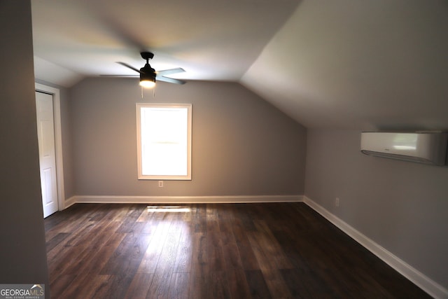 additional living space featuring dark wood-type flooring, a wall mounted AC, ceiling fan, and vaulted ceiling