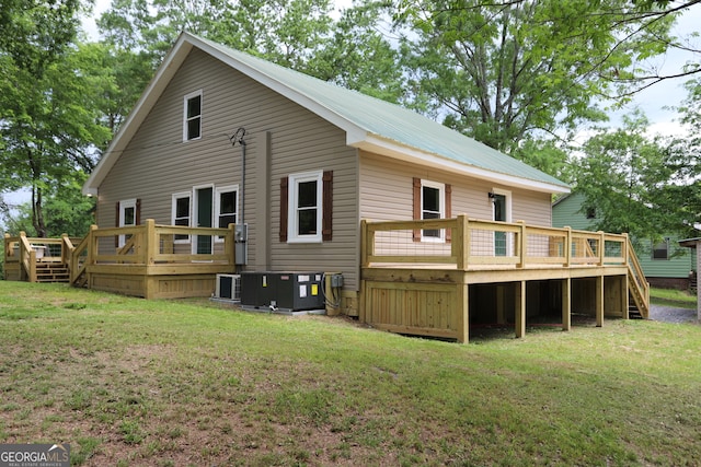 back of house with central air condition unit, a lawn, and a wooden deck