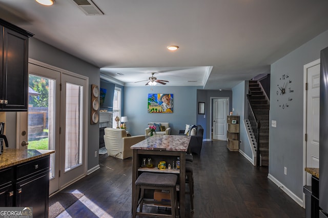 dining room with crown molding, ceiling fan, and dark hardwood / wood-style floors