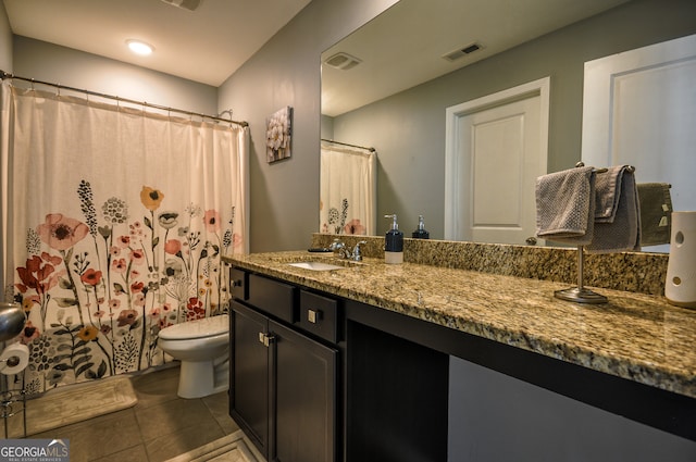 bathroom with vanity with extensive cabinet space, toilet, and tile floors