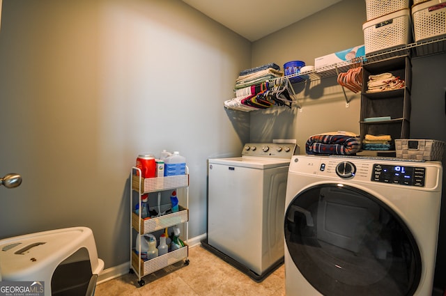 washroom featuring light tile floors and washer and dryer