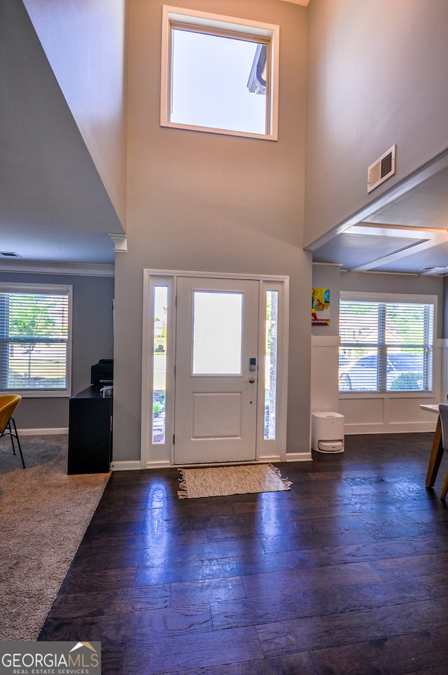 entrance foyer featuring dark hardwood / wood-style flooring and a towering ceiling