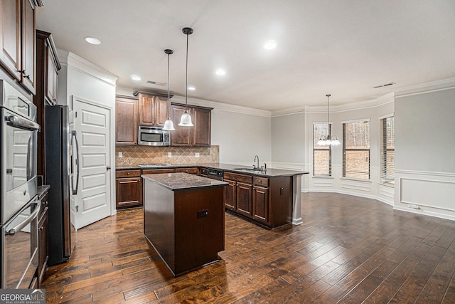 kitchen featuring a center island, stainless steel appliances, dark hardwood / wood-style flooring, a chandelier, and pendant lighting