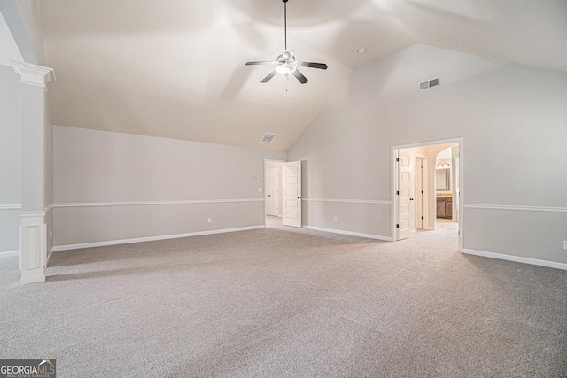 interior space with carpet flooring, ornate columns, ceiling fan, and high vaulted ceiling