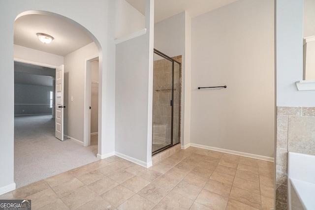 bathroom with tile patterned flooring and a shower with shower door