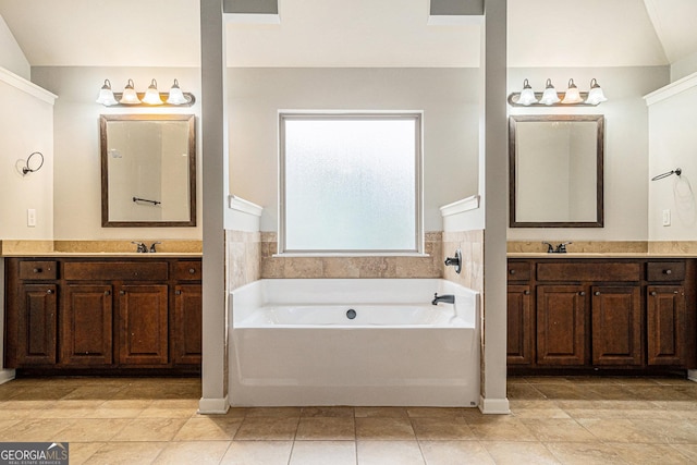 bathroom with a bathing tub, tile patterned flooring, and vanity