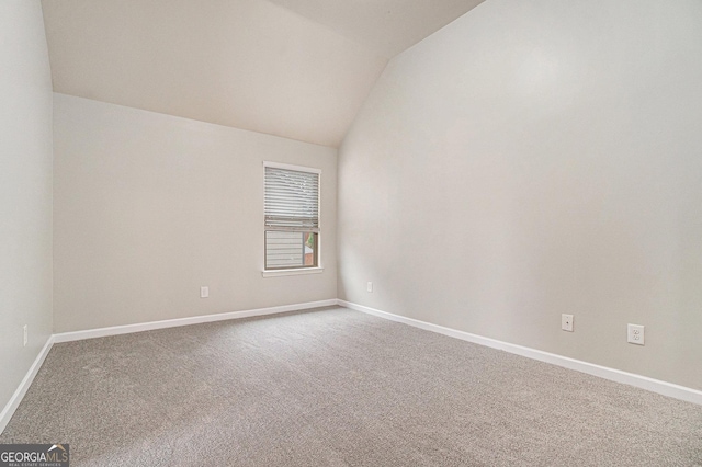 empty room with carpet and vaulted ceiling