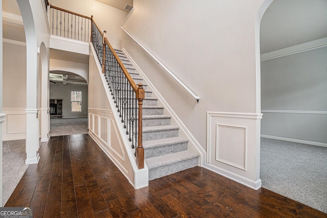 staircase with hardwood / wood-style flooring and ornamental molding