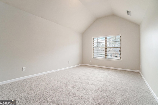 unfurnished room featuring carpet floors and vaulted ceiling