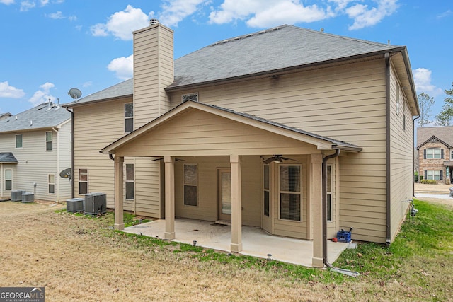 rear view of property featuring ceiling fan, cooling unit, a patio area, and a yard