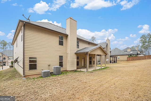 back of property with central AC unit, ceiling fan, a yard, and a patio