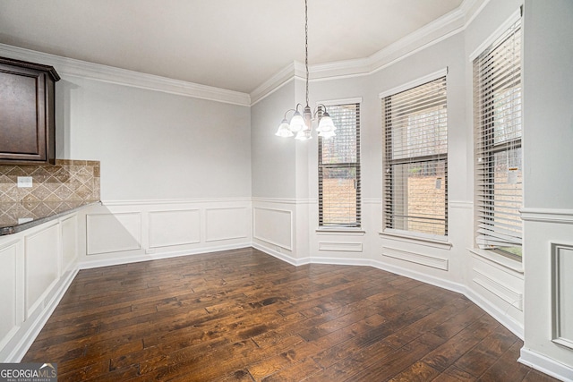 unfurnished dining area with crown molding, dark hardwood / wood-style floors, and a notable chandelier