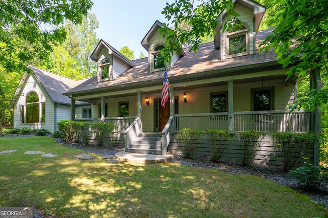 cape cod house featuring a front lawn and covered porch