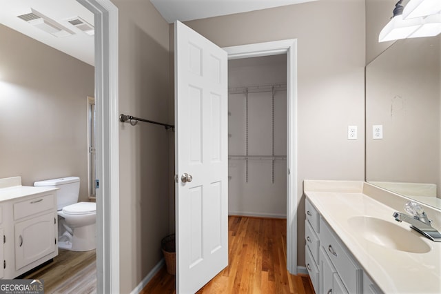 bathroom featuring wood-type flooring, vanity, and toilet