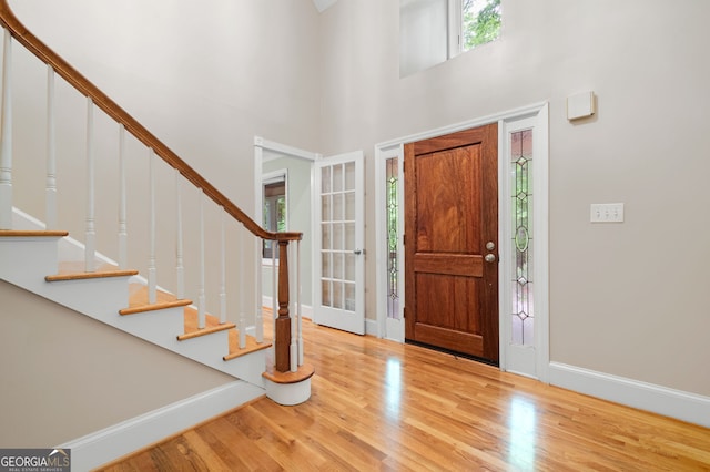 foyer with light hardwood / wood-style flooring and a high ceiling