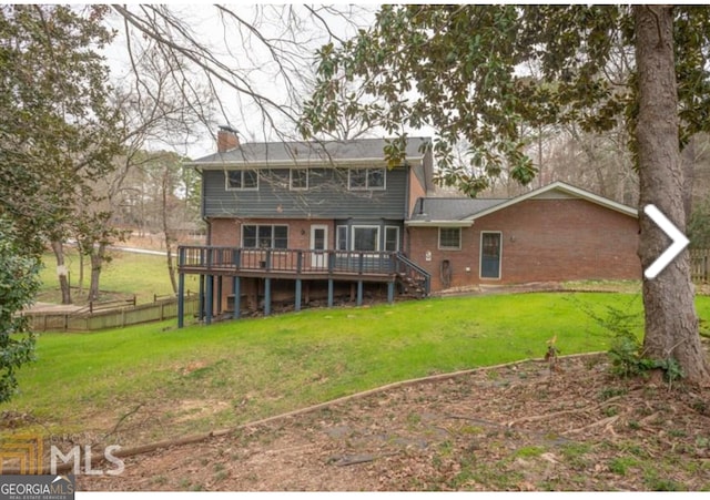 back of house featuring a deck and a lawn