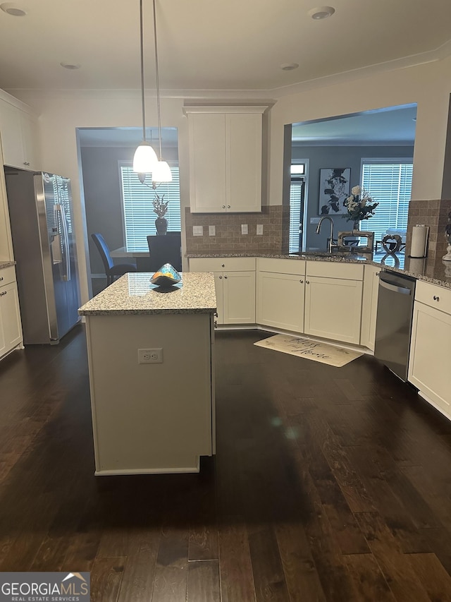 kitchen featuring backsplash, dark wood-type flooring, white cabinets, sink, and appliances with stainless steel finishes