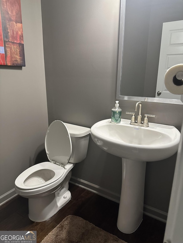 bathroom with hardwood / wood-style flooring and toilet