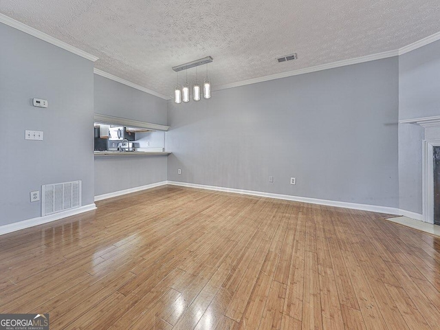 unfurnished living room featuring a textured ceiling, light hardwood / wood-style floors, and crown molding