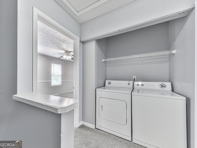 clothes washing area with light colored carpet, ceiling fan, and washer and dryer