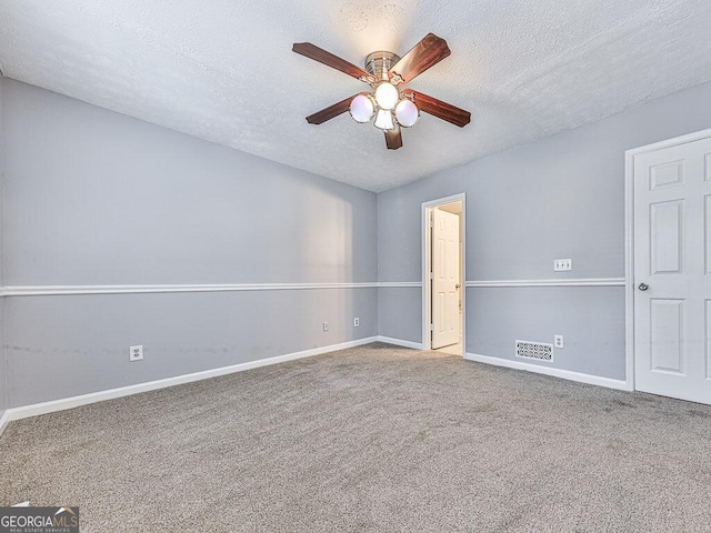 empty room with ceiling fan, carpet flooring, and a textured ceiling