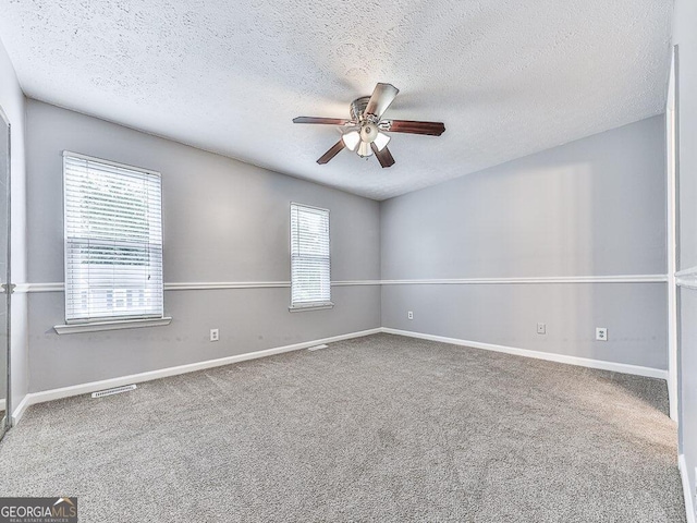 carpeted empty room featuring ceiling fan and a textured ceiling