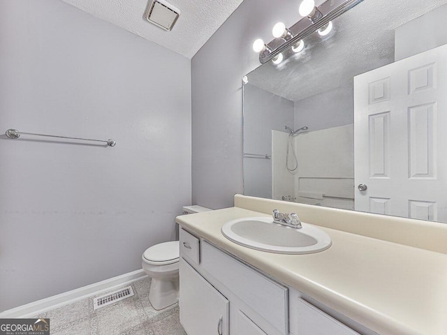 bathroom featuring toilet, oversized vanity, a textured ceiling, and tile flooring