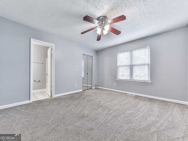 carpeted spare room with ceiling fan and a textured ceiling