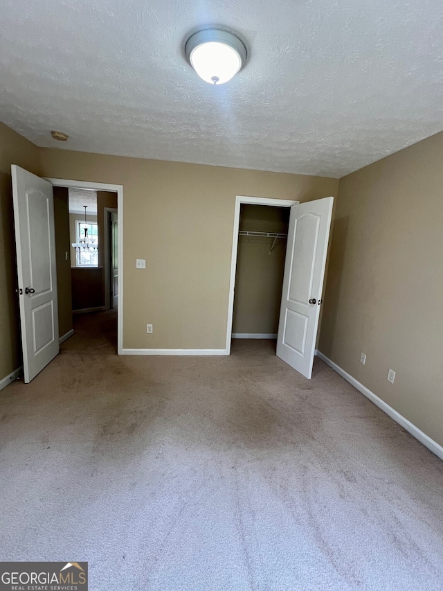 unfurnished bedroom with a closet, a textured ceiling, and carpet