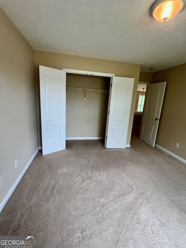 unfurnished bedroom featuring a closet, carpet flooring, and a textured ceiling