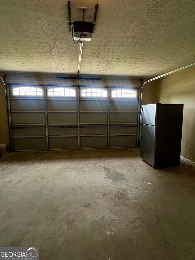 garage featuring a garage door opener and stainless steel fridge