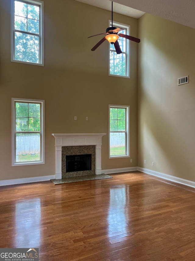 unfurnished living room featuring hardwood / wood-style floors, high vaulted ceiling, and ceiling fan