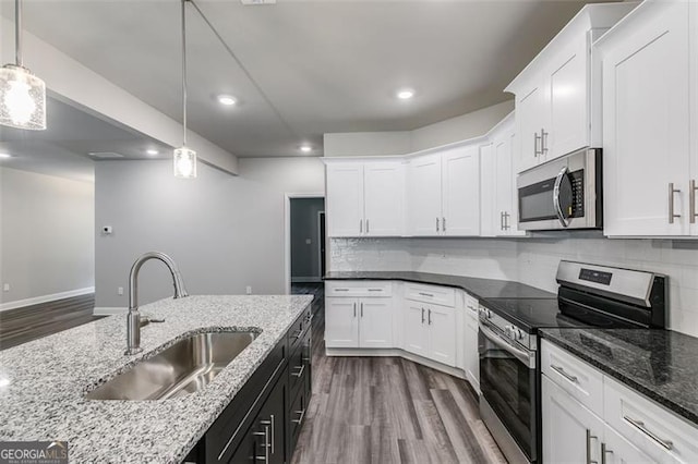 kitchen with stainless steel appliances, wood-type flooring, sink, and white cabinetry