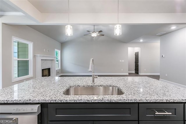 kitchen featuring a fireplace, hardwood / wood-style floors, pendant lighting, sink, and ceiling fan