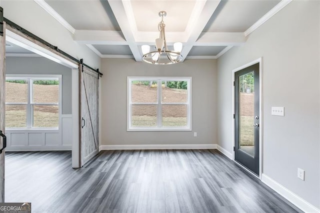 empty room featuring plenty of natural light, a barn door, coffered ceiling, and dark hardwood / wood-style flooring