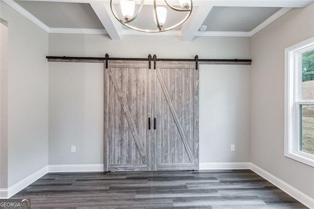 empty room featuring a barn door, dark wood-type flooring, coffered ceiling, and an inviting chandelier