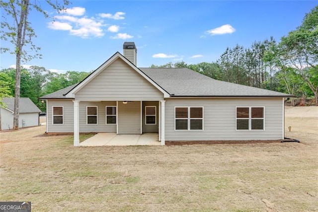 rear view of house with a patio area and a lawn