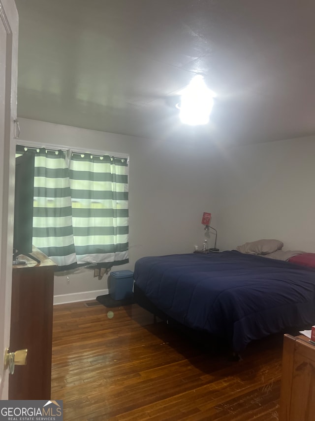 bedroom with dark hardwood / wood-style floors