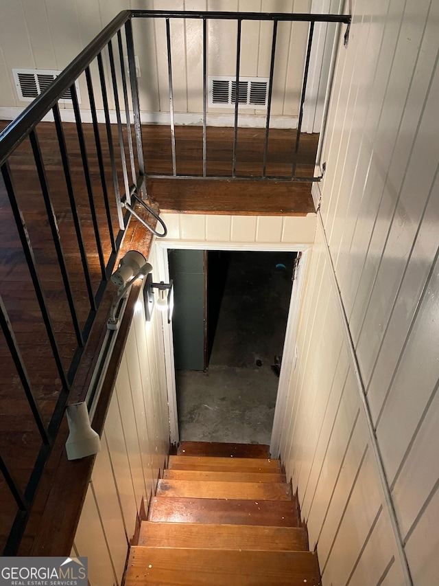 staircase featuring wooden walls