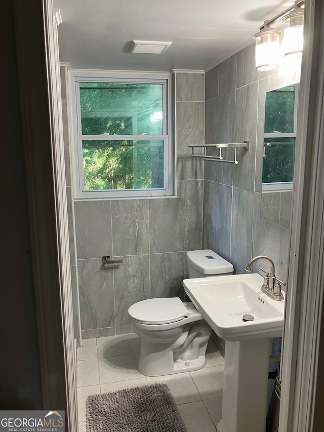 bathroom with tile patterned floors, tile walls, and toilet