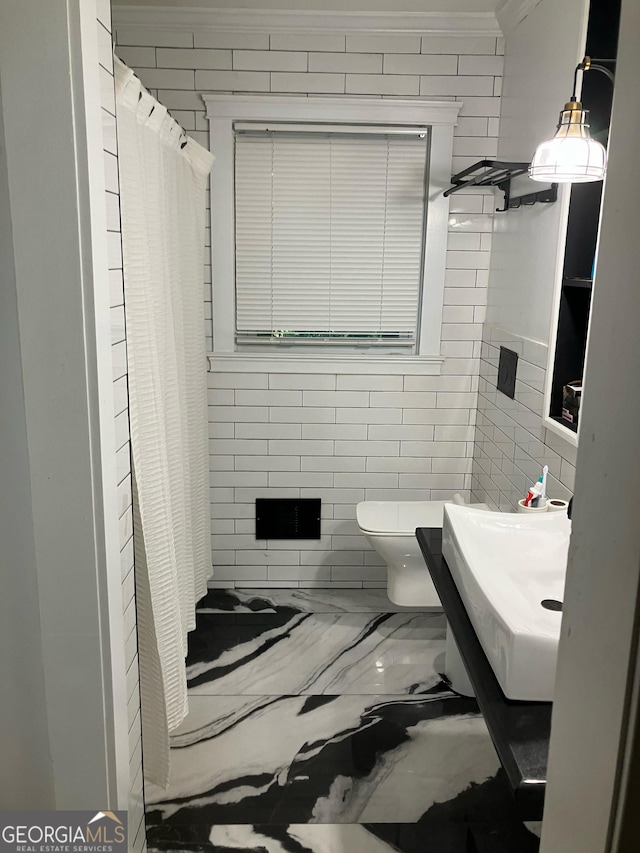 bathroom featuring toilet, curtained shower, crown molding, and sink