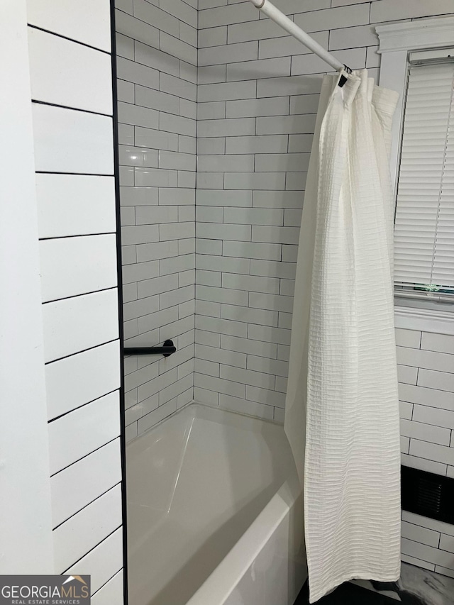 bathroom with shower / bath combo with shower curtain