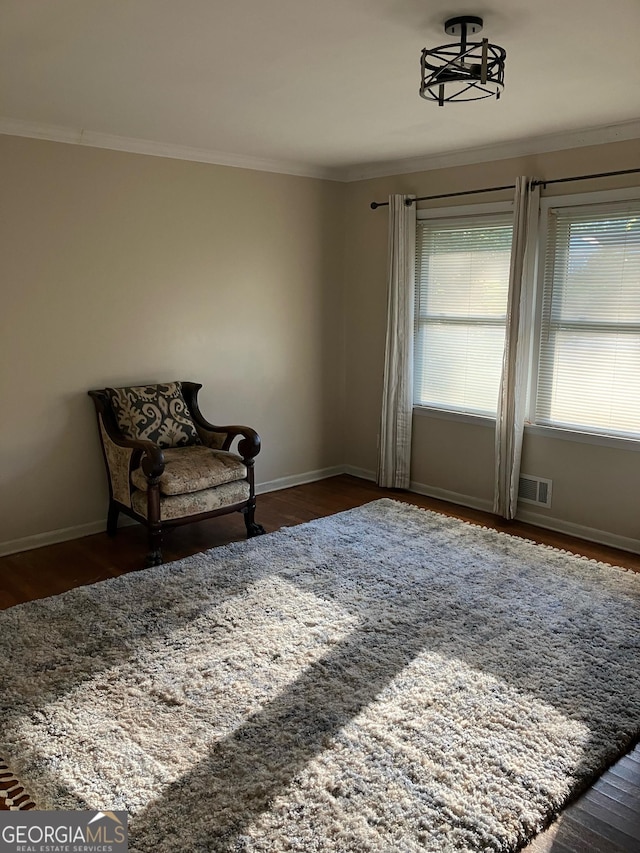 sitting room with dark hardwood / wood-style floors and crown molding