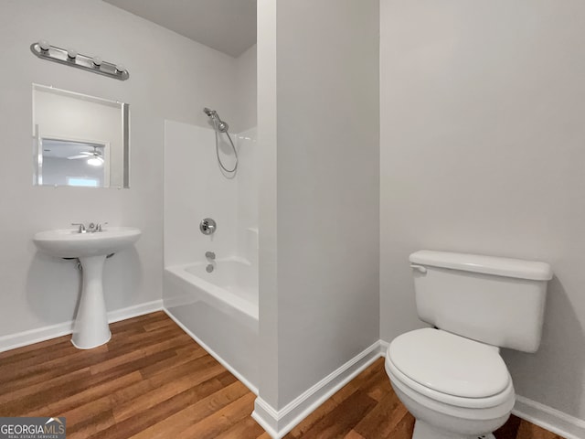 bathroom with wood-type flooring, ceiling fan, toilet, and bathing tub / shower combination