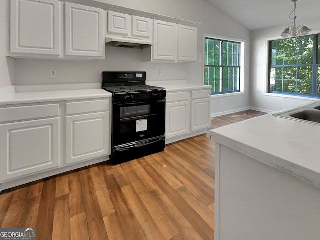 kitchen featuring black range with gas cooktop, white cabinets, a notable chandelier, vaulted ceiling, and light hardwood / wood-style floors