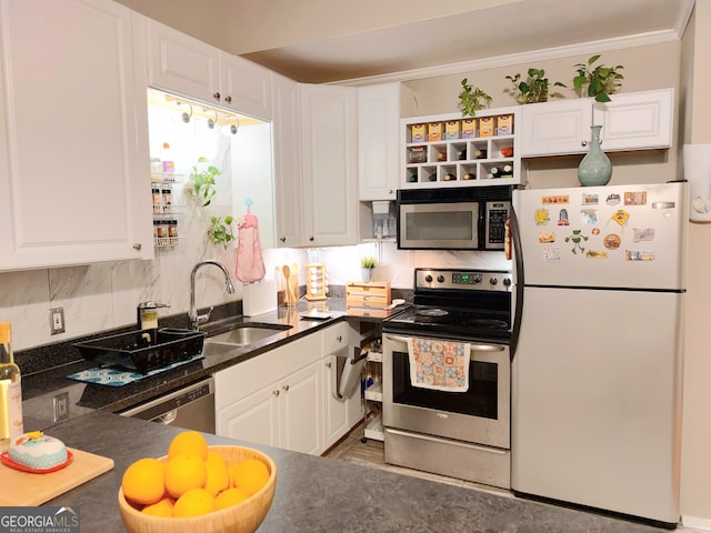 kitchen featuring sink, backsplash, white cabinetry, crown molding, and stainless steel appliances